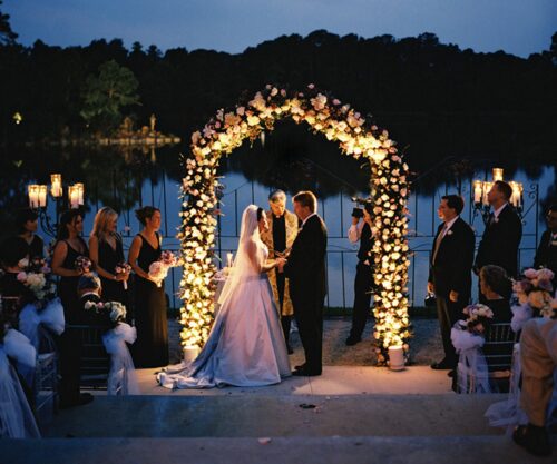 groom pushes wedding cake off table in front of guests, dramatic wedding moment caught on video, bride reacts emotionally, decorated cake with raspberries and blackberries on floor, Bona Magazine