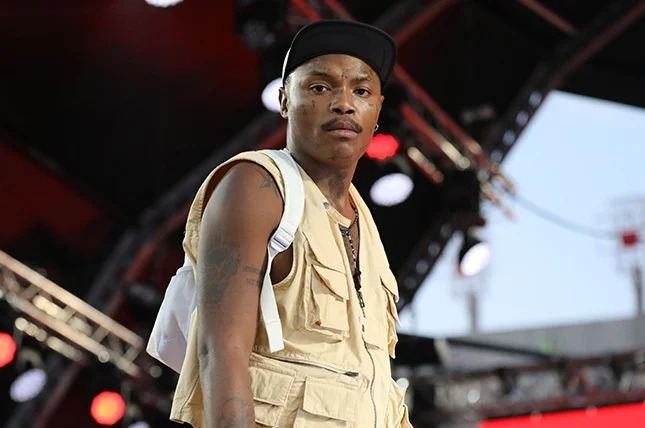 Shebeshxt in superhero outfit at Limpopo children’s party, musician doing push-ups on stage, colourful costume with kids laughing, South African artist viral moment, Bona Magazine