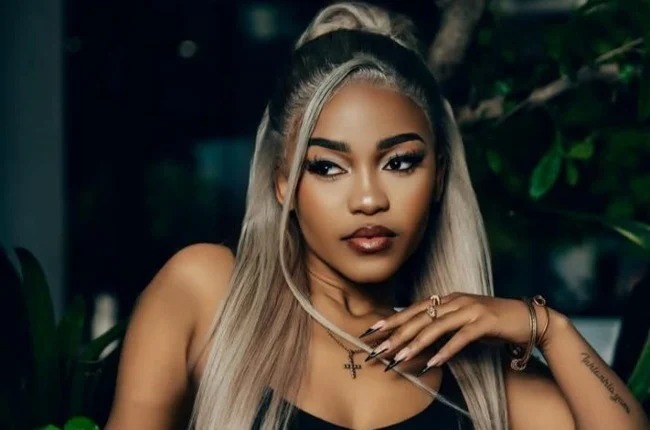 Zee Nxumalo modest white two-piece and hat, singer after backlash over revealing outfit, style evolution celebrity, Bona Magazine