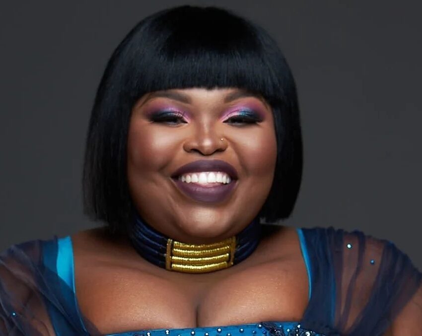 Gogo Maweni holding stacks of money like phone, viral sangoma cash video, South African responses tax jokes, social media reaction humorous, Bona Magazine