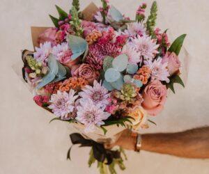 woman hesitating at crossroads, graduation bouquet, emotional breakup, relationship guilt, Bona Magazine