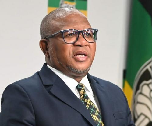 Fikile Mbalula speaking at media briefing, Pretoria courtroom building exterior, South African politics legal drama, Bona Magazine
