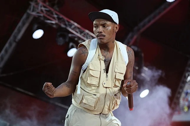 Shebeshxt on stage with microphone, female fan leaning in crowd, South African rapper viral clip, Bona Magazine