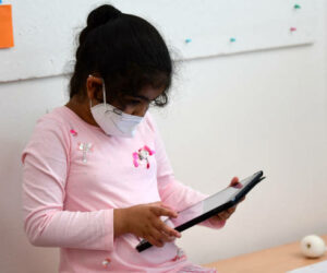 A pupil, wearing a protective face mask, works with an iPad during a summer project at the primary school 'Sonnenschule' in Beckum, western Germany, on July 6, 2021. North-Rhine Westphalia's Minister of Education and Schools visits projects that have received funding from the state programme "Extra Time for Learning" during the summer. (Photo by Ina FASSBENDER / AFP) (Photo by INA FASSBENDER/AFP via Getty Images)