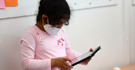 A pupil, wearing a protective face mask, works with an iPad during a summer project at the primary school 'Sonnenschule' in Beckum, western Germany, on July 6, 2021. North-Rhine Westphalia's Minister of Education and Schools visits projects that have received funding from the state programme "Extra Time for Learning" during the summer. (Photo by Ina FASSBENDER / AFP) (Photo by INA FASSBENDER/AFP via Getty Images)