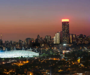 Cityscape of Johannesburg city skyline and stadium in the evening.