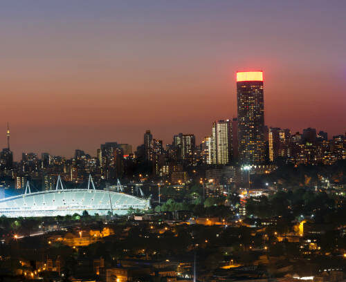 Cityscape of Johannesburg city skyline and stadium in the evening.