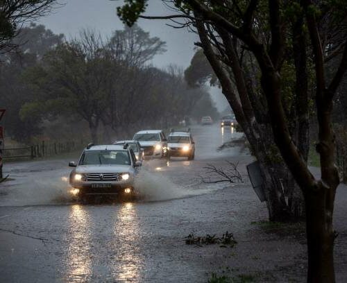 Automobiles on a flooded road in the Tokai suburb of Cape Town, South Africa, on Thursday, July 11, 2024. Cape Town, South Africa's tourism hub, and the surrounding Western Cape province have been battered by torrential rains, howling winds and bush fires that caused extensive damage to buildings, roads and other infrastructure.  Photographer: Dwayne Senior/Bloomberg via Getty Images