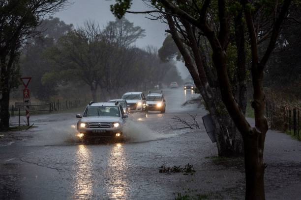 Automobiles on a flooded road in the Tokai suburb of Cape Town, South Africa, on Thursday, July 11, 2024. Cape Town, South Africa's tourism hub, and the surrounding Western Cape province have been battered by torrential rains, howling winds and bush fires that caused extensive damage to buildings, roads and other infrastructure.  Photographer: Dwayne Senior/Bloomberg via Getty Images