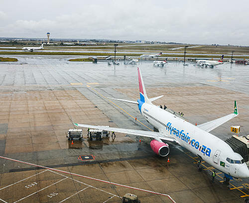 Airport ground staff attend the South African FlySafair low-cost airline Boeing 737-85P aircraft, while it is parked on the tarmac at OR Tambo International Airport in Ekurhuleni on March 12, 2026. Africa is feeling the impact of rising oil prices and threats to shipping, as the continent again suffers from events largely beyond its control. Pump prices in Nigeria were up around 14 percent this week. (Photo by Phill Magakoe / AFP via Getty Images)