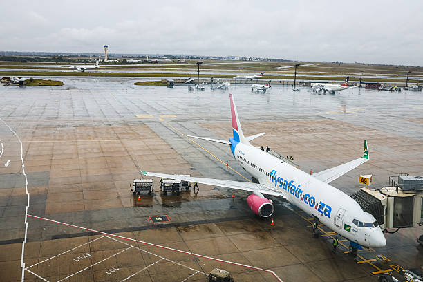 Airport ground staff attend the South African FlySafair low-cost airline Boeing 737-85P aircraft, while it is parked on the tarmac at OR Tambo International Airport in Ekurhuleni on March 12, 2026. Africa is feeling the impact of rising oil prices and threats to shipping, as the continent again suffers from events largely beyond its control. Pump prices in Nigeria were up around 14 percent this week. (Photo by Phill Magakoe / AFP via Getty Images)