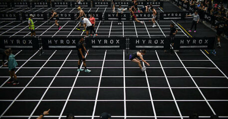 Participants compete in the "burpee broad jumps" event during the Hyrox fitness