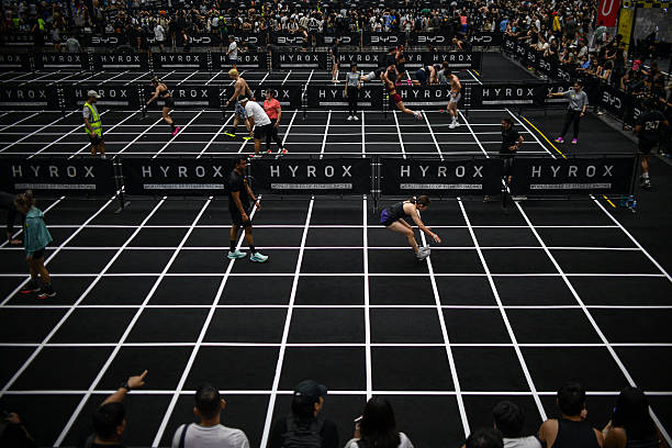 Participants compete in the "burpee broad jumps" event during the Hyrox fitness