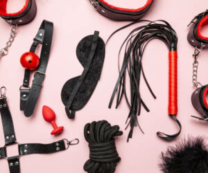 Set of erotic toys for BDSM. The game of sexual slavery with a whip, gag and leather blindfold. Intimate sex games