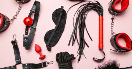 Set of erotic toys for BDSM. The game of sexual slavery with a whip, gag and leather blindfold. Intimate sex games