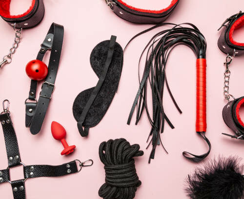 Set of erotic toys for BDSM. The game of sexual slavery with a whip, gag and leather blindfold. Intimate sex games